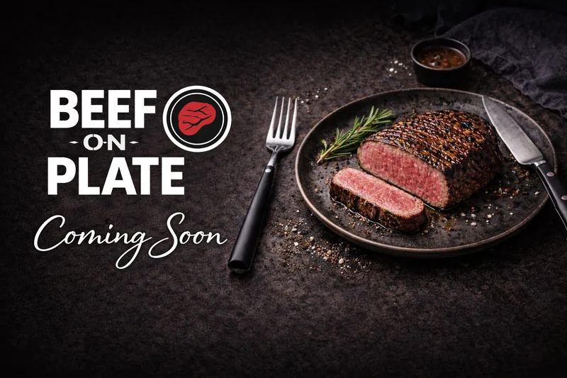 Beef on Plate logo with Coming Soon in white script beside a sliced seared beef joint on a dark plate with fork, knife and rosemary